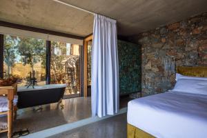 阿基欧斯帕夫洛斯Muar Suites的卧室设有一张床和一个靠窗的浴缸