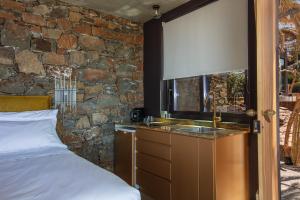 阿基欧斯帕夫洛斯Muar Suites的一间卧室设有水槽和石墙