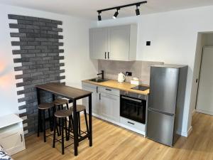 卡托维兹White and Black Apartments的厨房配有桌子和不锈钢冰箱。