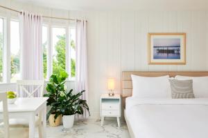 蒙托克The Sunset Montauk的白色卧室设有床、书桌和窗户