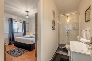 丰沙尔Villa das Furnas的一间卧室配有一张床,浴室设有淋浴。