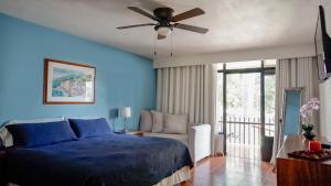 查帕拉Toca Madera的蓝色卧室配有床和吊扇