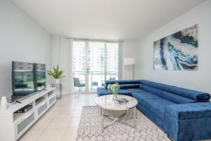 好莱坞Modern 1 BDR Oceanview with direct beach access!的客厅配有蓝色的沙发和电视