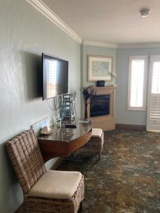 坎布里亚蓝海豚酒店 的客厅配有桌椅和电视。