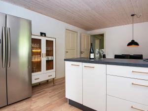 罗莫柯克比Holiday home Rømø XVII的厨房配有白色橱柜和不锈钢冰箱