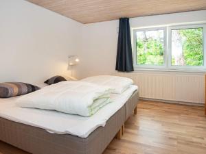 罗莫柯克比Holiday home Rømø XVII的一间卧室设有一张大床和两个窗户。