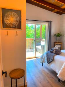 ForestvillePrivate Wine Country-River Bungalow! Sunny Treetop Views - Pets Stay Free的一间卧室设有一张床和一个滑动玻璃门