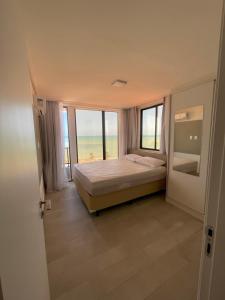 康德Apartamento Praia de Carapibus的一间卧室配有一张床,享有海景