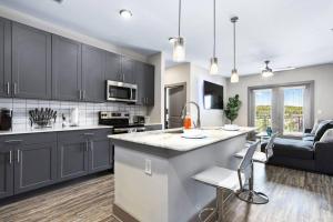 亚特兰大Luxury Buckhead Apartment的一间带灰色橱柜的厨房和一个带台面的厨房岛