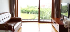 西归浦市Jeju Land Pension的带沙发和大窗户的客厅