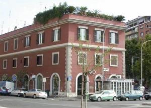 罗马克罗里迪罗马住宿加早餐旅馆的一座红砖建筑,前面停有汽车