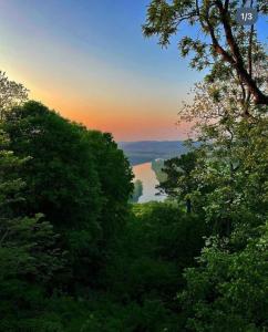 尤里卡斯普林斯White River Mountain Manor- Million dollar view的日落时分透过树林欣赏湖泊美景