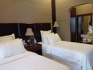 梭罗阿尔萨拉姆西里阿旅馆的两间相邻的床铺位于酒店客房内