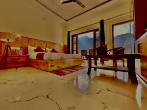 穆索里Sitara Hotel & Resort, ! Most Awarded Property in Mussoorie的卧室配有一张床、一张书桌和窗户。