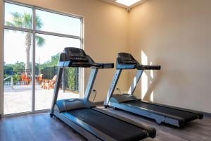 奥兰多SPOT X Hotel Orlando Intl Dr by The Red Collection的健身房设有两台跑步机和大窗户