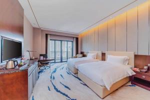 惠州Ramada By Wyndham Huizhou South的酒店客房设有两张床和电视。