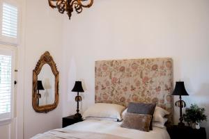 BraidwoodThe Doncaster的一间卧室配有一张带花卉床头板和镜子的床