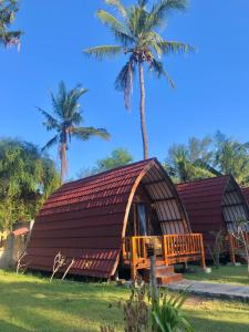 吉利美诺Blue Moon Meno的茅草屋顶和棕榈树度假屋