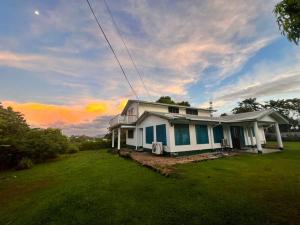 阿皮亚Heavenly Home的草坪上的房屋,背景是日落