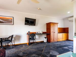 伦马克Hotel Renmark的客房设有书桌和墙上的电视。