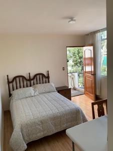 利马Habitación con baño propio para 2 personas como máximo的一间卧室设有一张床,并有通往庭院的门