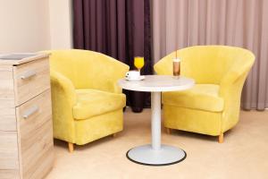 盖夫盖利亚参议员赌场汽车旅馆的两把黄色椅子和一张桌子,桌子上放着杯子和玻璃