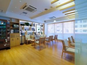 东京Far East Village Hotel Tokyo, Asakusa的一间设有椅子和桌子的等候室和一个沙龙