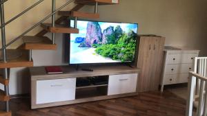 久洛Lagom Apartman的木质娱乐中心的平面电视