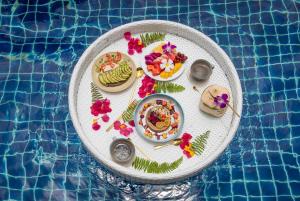 攀瓦海滩Soul Villas by The Beach - Phuket的游泳池旁餐桌上的一盘食物