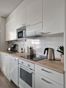 于韦斯屈莱Huhta Sport的白色的厨房配有白色橱柜和茶壶