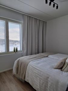 于韦斯屈莱Huhta Sport的白色的卧室设有床和窗户