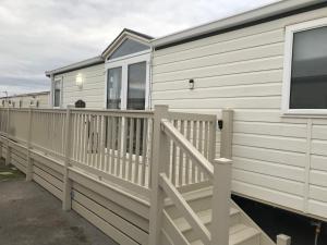 拉尔Hot Tub Accommodation North Wales Caravan的移动房屋 - 带门廊和甲板