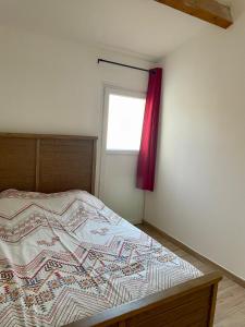马里尼亚讷Cocon en Provence的一间卧室配有一张带红色窗帘的床
