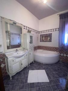 兰佩杜萨VILLA HELENA的带浴缸、水槽和浴缸的浴室