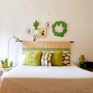 阿莱萨诺Masseria delle Rose 1760的一间卧室配有一张带绿色枕头的床