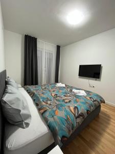 斯科普里Skopje Centar Margarita Luxury Aprtment(Private Parking)的一间卧室配有一张床和一台平面电视