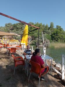 KöyceğizEs&Es campıng ve bungalov的坐在水边桌子上的两个人