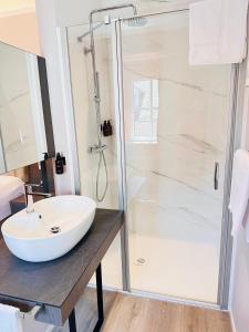 特里尔MEA HOTEL TRIER的浴室配有白色水槽和淋浴。