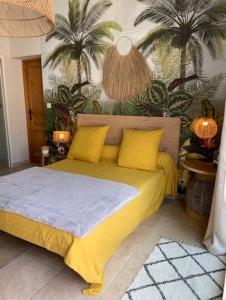 拉西约塔Chambre d'hôtes Chante Cigale的一间卧室配有一张带黄色枕头和棕榈树的床。