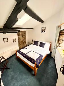 汤顿The Snuggery Cottage的一间卧室设有一张床和石墙