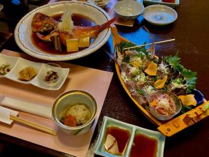 热海Pension Todoroki的餐桌,有两盘食物和碗食物