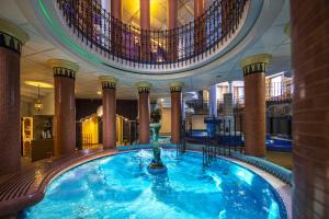 佐洛埃格塞格Willis Hotel Business & Wellness的一座带喷泉的建筑里的大型室内游泳池