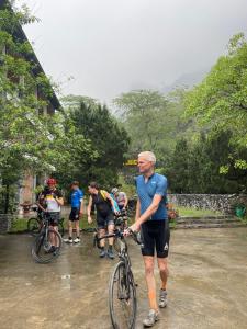河江Ha Giang Historic House & tour的一群人在雨中骑着自行车
