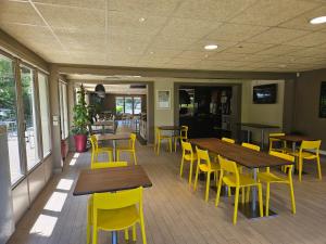 多维尔钟楼道维拉圣阿奴特酒店的餐厅设有木桌和黄色椅子
