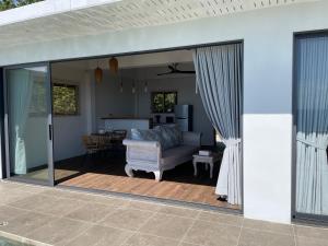 沙拉海滩LOLISEA Luxe view villas的开放式庭院门,配有沙发和桌子