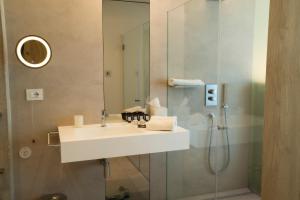 新福卡Posia Retreat & Spa UNA Esperienze的一间带水槽和淋浴的浴室