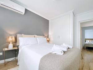 格兰阿利坎特Casa Natura Sunset Beach的白色卧室,配有带毛巾的床