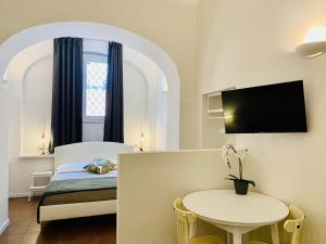 罗马Eccelso Suites的客房设有床、桌子和窗户。