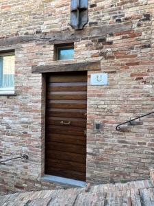 乌尔比诺Urbino Apartment - Torricini View的砖楼木车库门