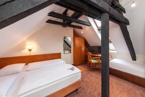 科隆Hotel Ahl Meerkatzen的阁楼卧室配有两张床和一张书桌